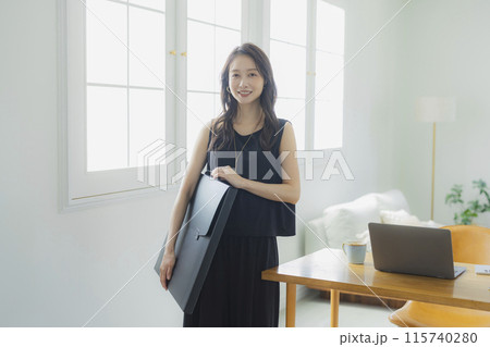 アートポートフォリオバッグを持つ若い女性　 115740280
