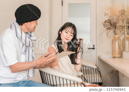 美容室で髪の毛の悩みを美容師さんに相談する女性 美容室で髪の毛の悩みを美容師さんに相談する女性 115740941