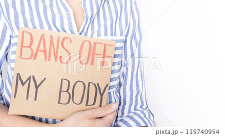 Woman holding Bans Off My Body sign at reproductive rights rally in city center during sunny day Woman holding Bans Off My Body sign at reproductive rights rally in city center during sunny day 115740954