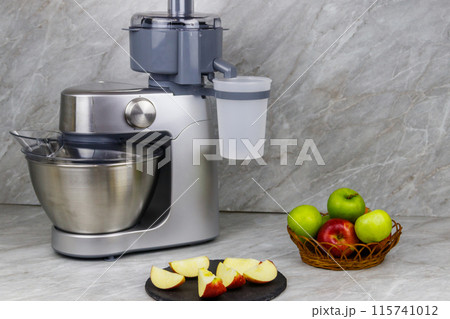 Modern electric juicer and apples on a kitchen table Modern electric juicer and apples on a kitchen table 115741012