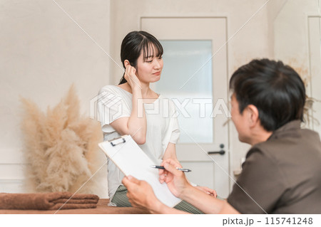 整体院・整骨院・マッサージに通う女性と整体師・セラピスト（耳） 115741248