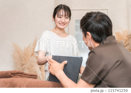整体院・整骨院・マッサージのカウンセリングを受ける女性と整体師・セラピスト（タブレットPC） 115741250