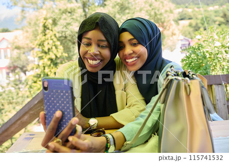 Middle Eastern Muslim Women Capturing Selfies in Serene Surroundings Middle Eastern Muslim Women Capturing Selfies in Serene Surroundings 115741532