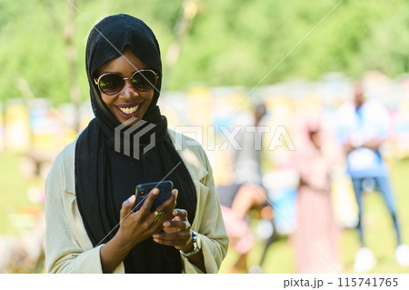 Empowered Middle Eastern Muslim Woman in Hijab Balances Modern Technology and Traditional Beekeeping Business 115741765