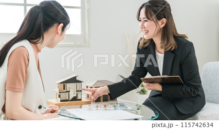マイホーム・不動産・リフォーム・資産運用の説明・営業をするビジネスウーマンと相談するアジア人女性 115742634