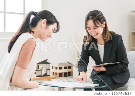 マイホーム・不動産・リフォーム・資産運用の説明・営業をするビジネスウーマンと相談するアジア人女性 115742637