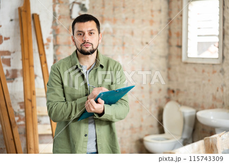 Architect making notes on indoor construction site Architect making notes on indoor construction site 115743309