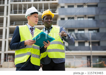 Engineers standing on construction site Engineers standing on construction site 115743465