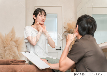 リンパマッサージ・リンパ整体のカウンセリングを受ける女性と整体師・セラピスト 115743470