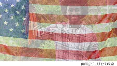 Image of flag of united states of america over happy african american farmer keeping carrots 115744538