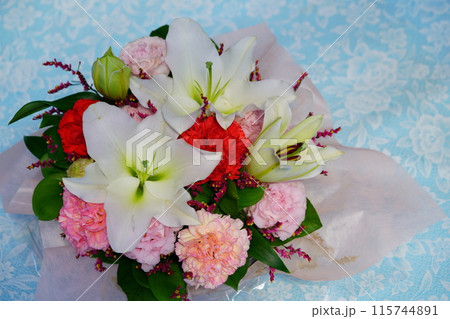 母の日ギフトのフラワーアレンジメント・背景ブルー 115744891