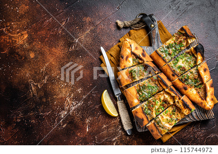 Traditional Turkish baked pide, Middle Eastern snack. Turkish pizza. Dark background. Top view. Copy space Traditional Turkish baked pide, Middle Eastern snack. Turkish pizza. Dark background. Top view. Copy space 115744972
