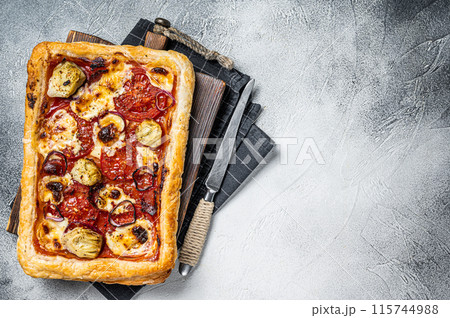 Vegetarian puff pastry pizza with artichoke, mozzarella, tomatoes and cheese. White background. Top view. Copy space 115744988