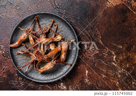 Spicy Dip fried duck tongue. Dark background. Top view. Copy space 115745002