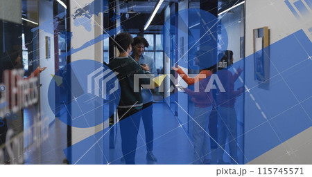 Image of multiple graphs and diverse colleagues discussing documents in office corridor 115745571
