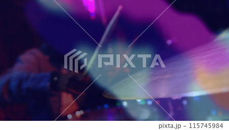 Image of colourful light blurs over africna american man playing on drum kit in slow motion Image of colourful light blurs over africna american man playing on drum kit in slow motion 115745984