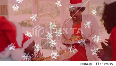 Image of snow falling over smiling family with santa hats having dinner Image of snow falling over smiling family with santa hats having dinner 115746049