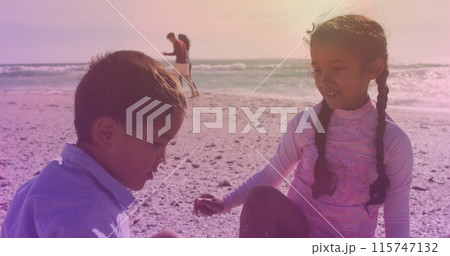 Spots of light against hispanic brother and sister high fiving each other at the beach Spots of light against hispanic brother and sister high fiving each other at the beach 115747132
