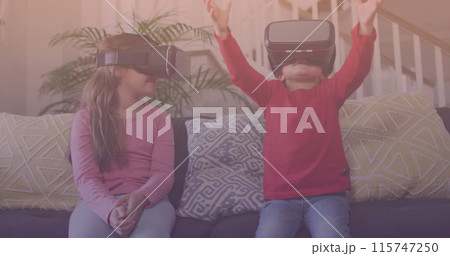 Spots of light against caucasian brother and sister wearing vr headset at home 115747250
