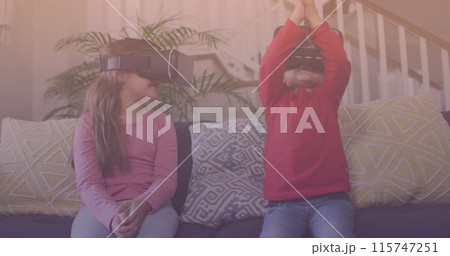 Spots of light against caucasian brother and sister wearing vr headset at home Spots of light against caucasian brother and sister wearing vr headset at home 115747251