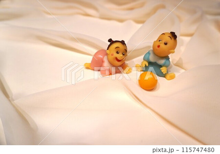 白い布の上でボールで遊ぶ赤ちゃんの男の子と女の子 115747480