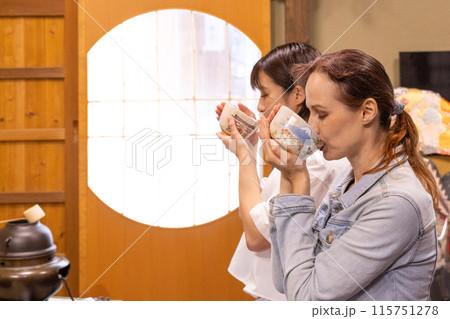 茶道体験をする外国人女性観光客と案内役の日本人女性 115751278