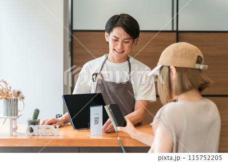 カフェのレジ・会計で電子決済・スマホ決済に対応するカフェ店員 115752205