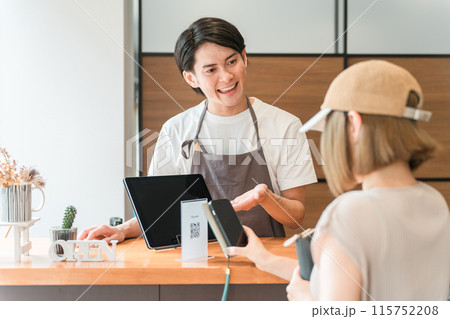 カフェのレジ・会計で電子決済・スマホ決済に対応するカフェ店員 115752208