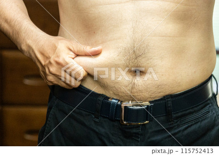 ポッコリおなかの中年男性の体　　お腹を触っている 115752413