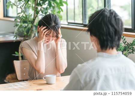 デートでカフェ・飲食店・レストランでショックを受けて泣く女性（悲しい・夫婦喧嘩） 115754059