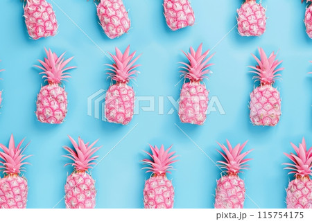 Pattern of pink pineapples on blue background creating a vibrant and playful design 115754175