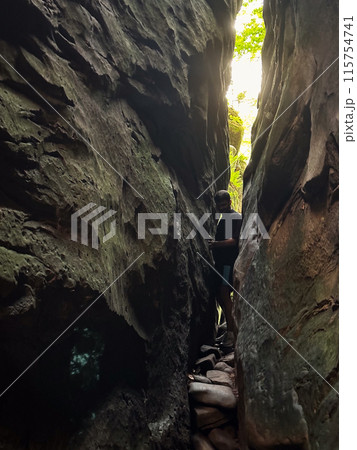man tourist hiking by rocks on forest man tourist hiking by rocks on forest 115754741