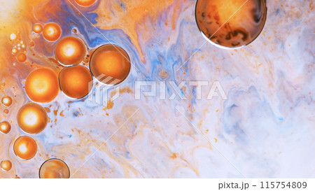 Top view of macro abstract photography of oil droplet on gragient yellow to orange background 115754809