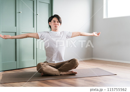 家で柔軟体操・体操・ストレッチする若いアジア人男性 115755562