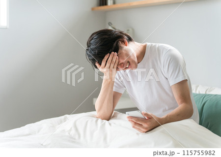 ベッドで二度寝・寝落ちしてしまうアジア人男性（鬱病・寝坊・低血圧・落ち込む） 115755982