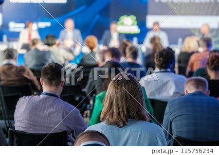 Audience attending a conference with multiple speakers on stage Audience attending a conference with multiple speakers on stage 115756234