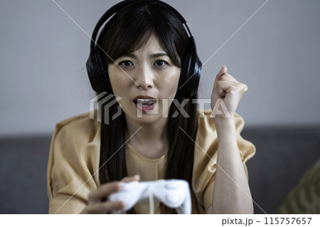 ゲームに熱中するミドルの女性 115757657