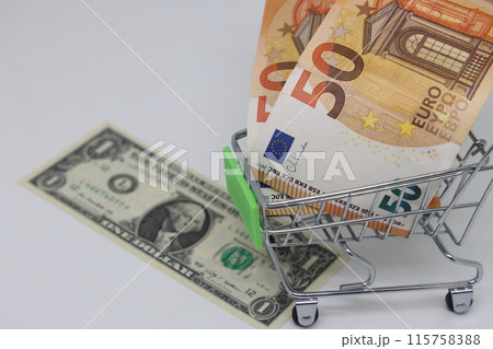 Toy grocery cart and banknotes, shopping for goods, exchange rate volatility. Toy grocery cart and banknotes, shopping for goods, exchange rate volatility. 115758388