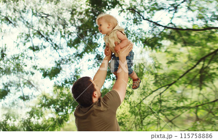 Happy father and son, joyful dad playing with child, holding on hands in the park 115758886