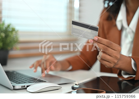 Closeup businesswoman holding credit card and using laptop for make transactions online 115759366