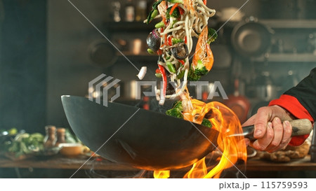 Freeze Motion of Wok Pan with Flying Asian Meal in the Air. Freeze Motion of Wok Pan with Flying Asian Meal in the Air. 115759593