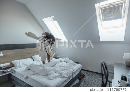 woman exuberantly jumping on her bed, expressing freedom and the pure joy woman exuberantly jumping on her bed, expressing freedom and the pure joy 115760771