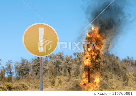 A yellow sign with an exclamation point on it is next to a fire 115760891