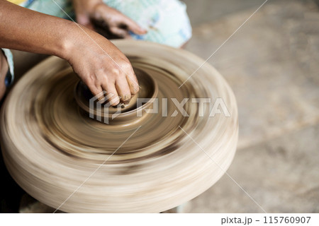 Human hand sculpting a craft from raw clay Human hand sculpting a craft from raw clay 115760907