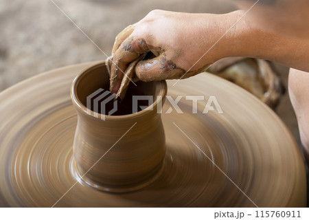 Human hand sculpting a craft from raw clay 115760911