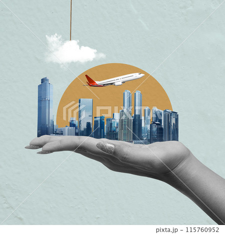 A hand holding a model airplane in front of a cityscape 115760952