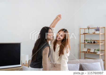 Joyful Lesbian Couple Dancing Together in Modern Cozy Living Room with Minimalist Decor 115760997