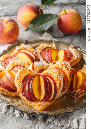 Festive peach puff in the shape of a heart with fresh fruit and jam close-up in a plate. Vertical 115762801