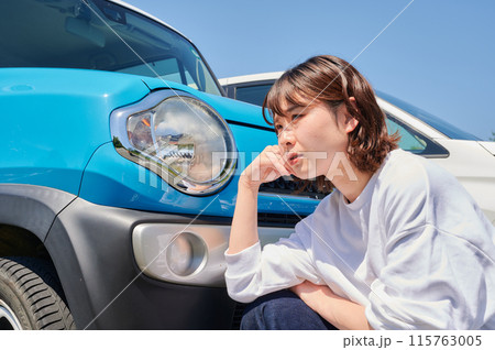 車の前で頭を抱える女性 パンク トラブル 車の前で頭を抱える女性 パンク トラブル 115763005