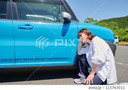 車の前で頭を抱える女性 パンク トラブル 車の前で頭を抱える女性 パンク トラブル 115763011